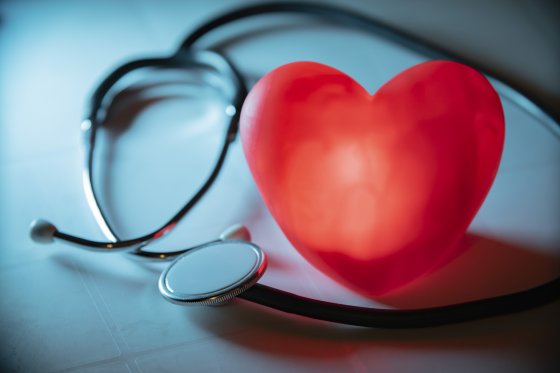 Red heart with stethoscope on blue background. Copy space